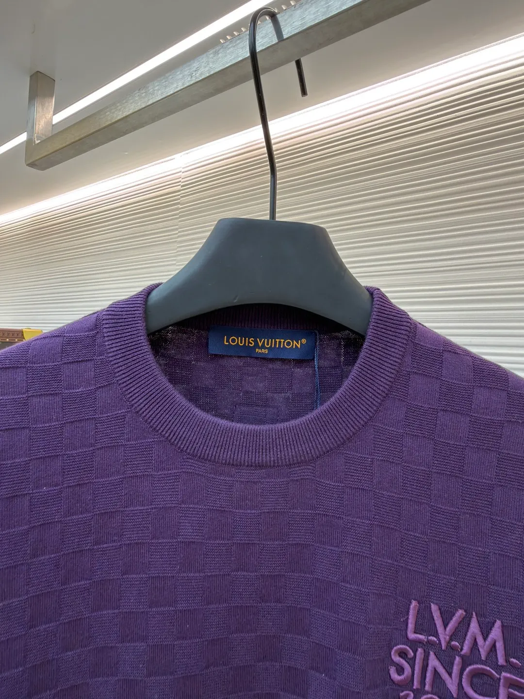 LOUIS VUITTON letter embroidered dark checkerboard jacquard short sleeves ●Original version: Purchased and developed at 9350 ●Item number: 1682319-B00 ●Fabric: 100% cotton ●Technology: jacquard knitting ●Color: Purple ●Version: Fitted version ●Weight: about 340 grams ●Size: S-M-L-XL ●Description: This Louis Vuitton purple knitted short-sleeve is made of custom worsted wool blended fabric. It is created with an 18-needle high-density weaving process using a computerized flat knitting machine to create a three-dimensional checkerboard texture. The checkered pattern is laser positioned and patterned. The size and spacing of each grid are accurate to 0.1 cm, showing a regular relief texture. The left chest uses same-color inlay embroidery technology, and the "LVM SINCE 1854" logo is embroidered with a high density of 1200 stitches/square centimeter. The embroidery thread is made of high-elastic mercerized cotton thread of the same color as the body, forming a natural texture layer with the knitted base. The neckline adopts seamless cylindrical rib technology, which is not easy to loose after high-temperature shaping treatment. The shoulders are made of seamless bonding technology to reduce the abruptness of the seams. The overall micro-profile tailoring combined with the invisible stitching technology of the side seams not only ensures the comfort of wearing, but also makes the body lines smoother. Each process has undergone multiple quality control tests by the brand to ensure the quality and durability of the craftsmanship. The overall wiring is straight and delicate, the fabric is comfortable and soft, and the color is consistent without color difference. It can be matched with the same style to create a fashionable look and control various occasions. Customized accessories, complete with three standards, same style for men and women!